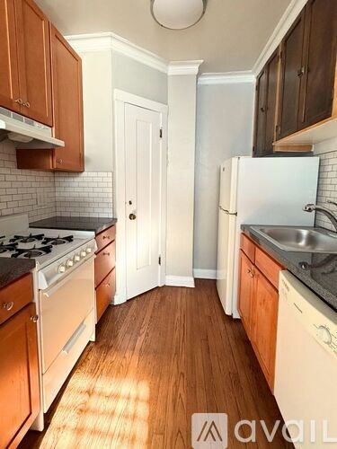 A kitchen with wooden cabinets and a white fridge.