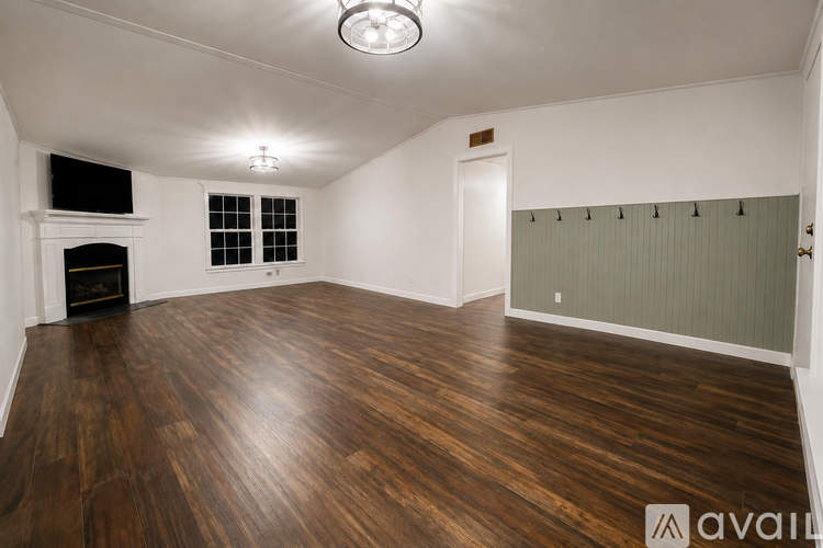 A room with wooden floors and a fireplace.