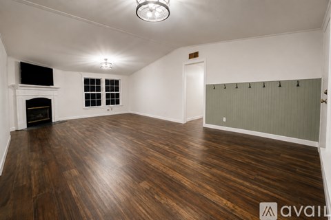 A room with wooden floors and a fireplace.