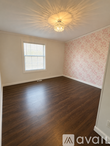 A room with wooden floors and a wallpapered wall.