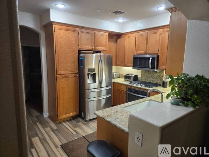 A kitchen with wooden cabinets and a granite countertop.