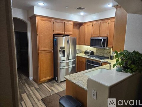 A kitchen with wooden cabinets and a granite countertop.