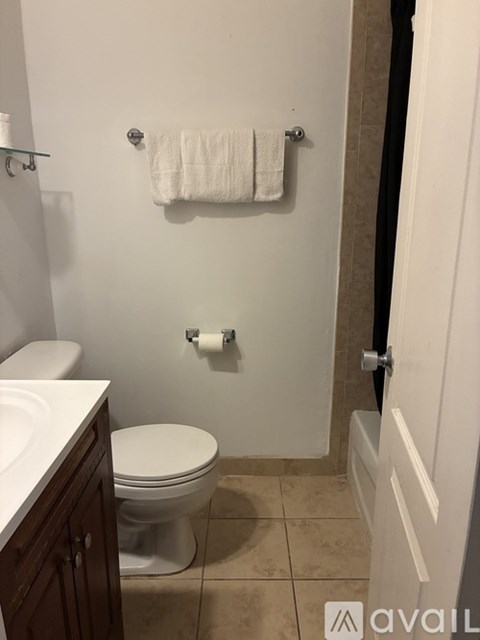 A white toilet in a bathroom with a towel rack above it.