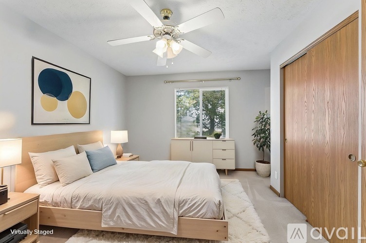 A bedroom with a bed, dresser, and ceiling fan.