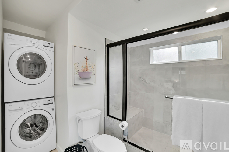 A bathroom with a washer and dryer stacked on top of each other.