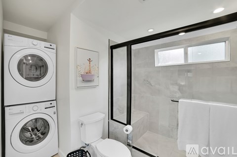 A bathroom with a washer and dryer stacked on top of each other.