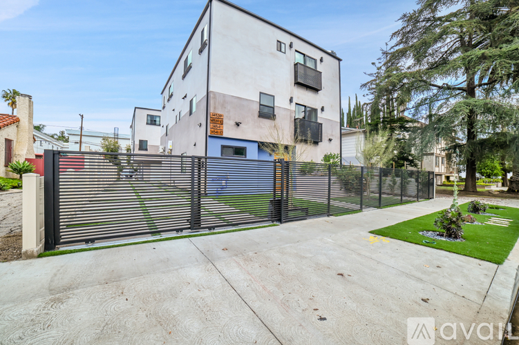A modern house with a white exterior and a black fence.