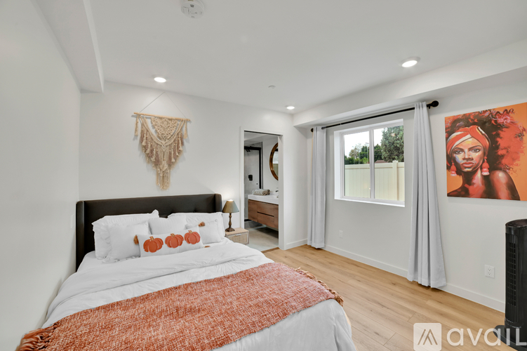 A bedroom with a large bed and a painting on the wall.