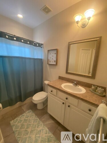 A bathroom with a toilet, sink, and mirror.