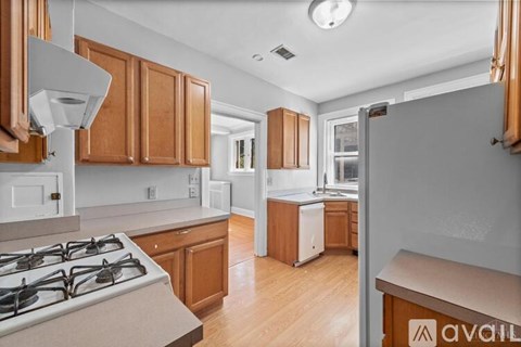 A kitchen with wooden cabinets and a stove top oven.