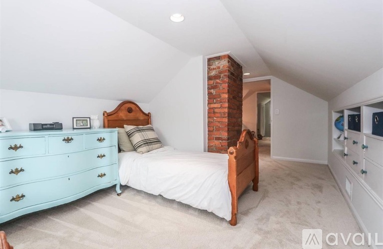 A bedroom with a blue dresser and a wooden bed.