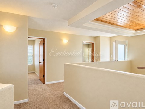 A spacious room with a carpeted floor and a wooden ceiling.