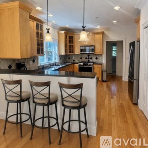 A kitchen with wooden cabinets and black countertops.