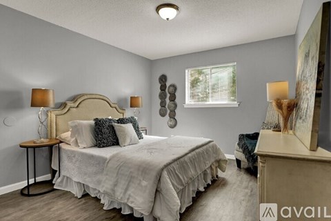 A bedroom with a large bed and a window with blinds.