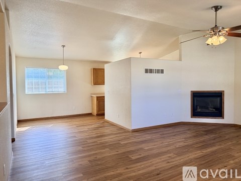 A living room with a fireplace and a ceiling fan.