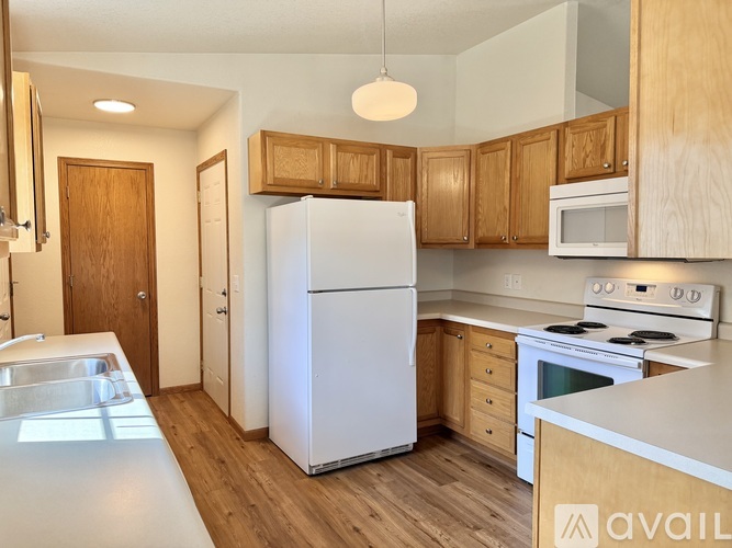 A kitchen with wooden cabinets and white appliances.