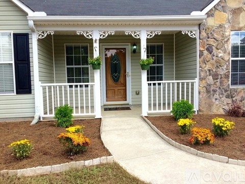 A house with a brown door and a white porch.