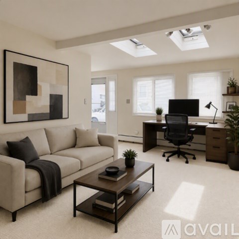 A modern living room with a beige sofa, a black office chair, and a large abstract painting on the wall.
