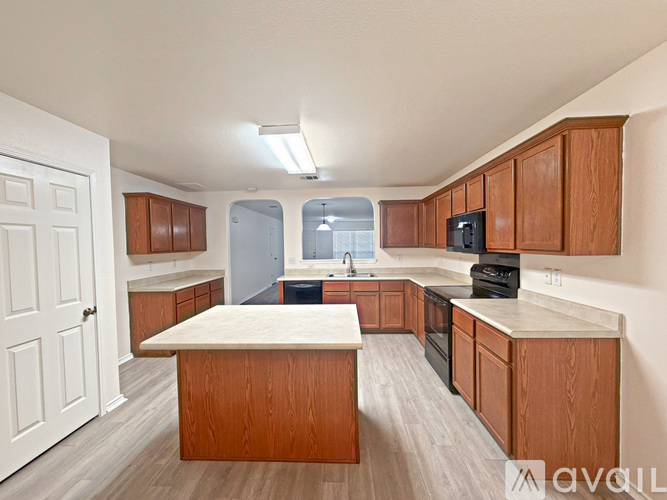 A kitchen with wooden cabinets and a white island.