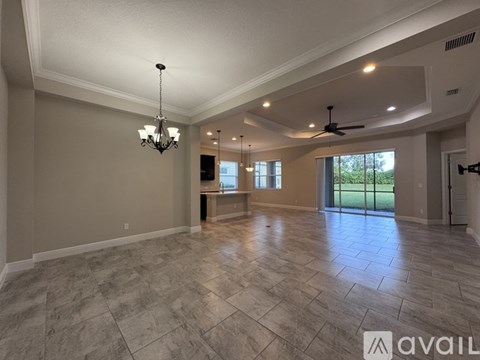 A spacious room with a chandelier and a ceiling fan.
