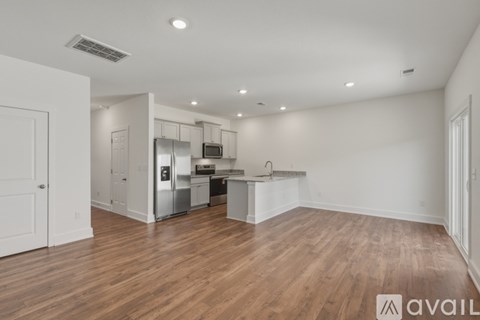 A kitchen area with a refrigerator, oven, and sink.