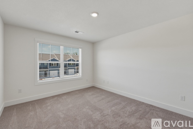 A room with a window showing a view of a building outside.