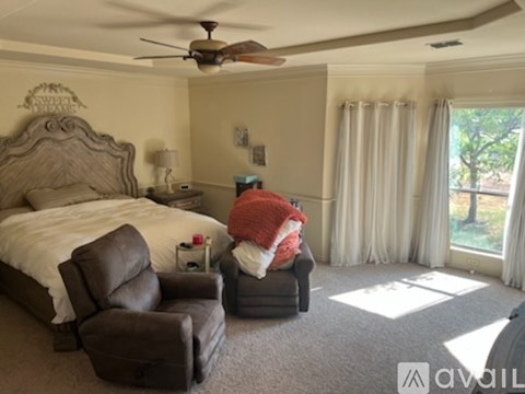 A bedroom with a large bed and a ceiling fan.