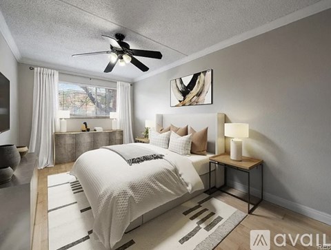 A bedroom with a large bed and a ceiling fan.