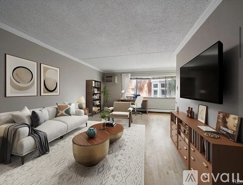 A living room with a white couch, a wooden coffee table, and a flat-screen TV mounted on the wall.