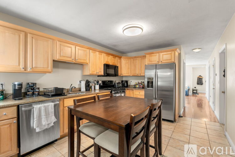 A kitchen with wooden cabinets and a table with chairs.