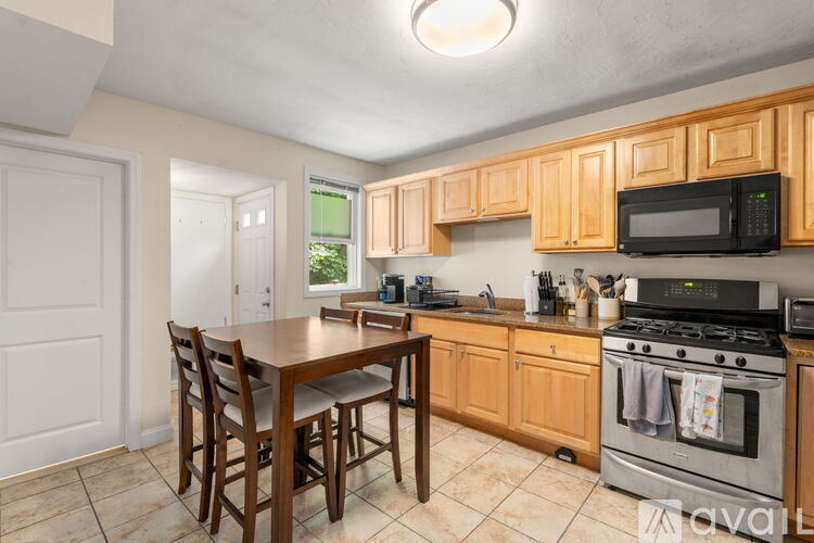 A kitchen with wooden cabinets and a tile floor.