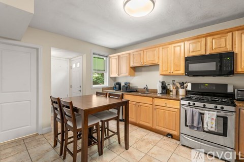 A kitchen with wooden cabinets and a tile floor.