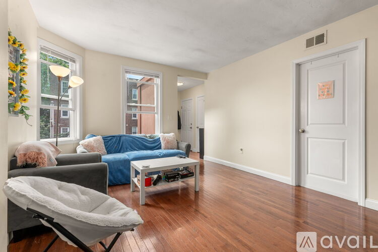 A living room with a grey couch, a blue sofa, a coffee table, and a chair.