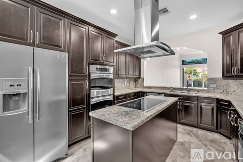 A kitchen with dark brown cabinets and stainless steel appliances.