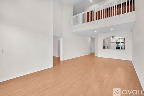 A large empty room with wooden floors and white walls.