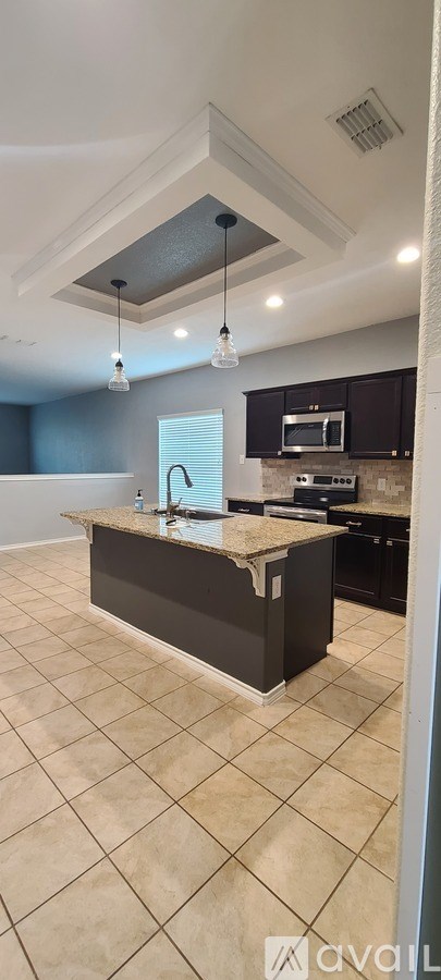 A kitchen with a countertop and a microwave.