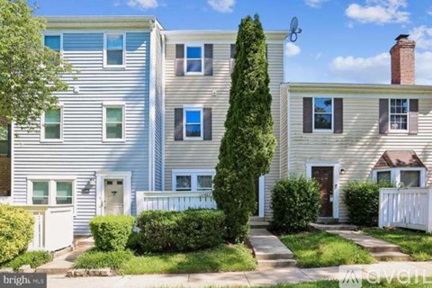 A row of houses with a white picket fence in front.