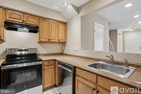 A kitchen with wooden cabinets and a black stove top oven.