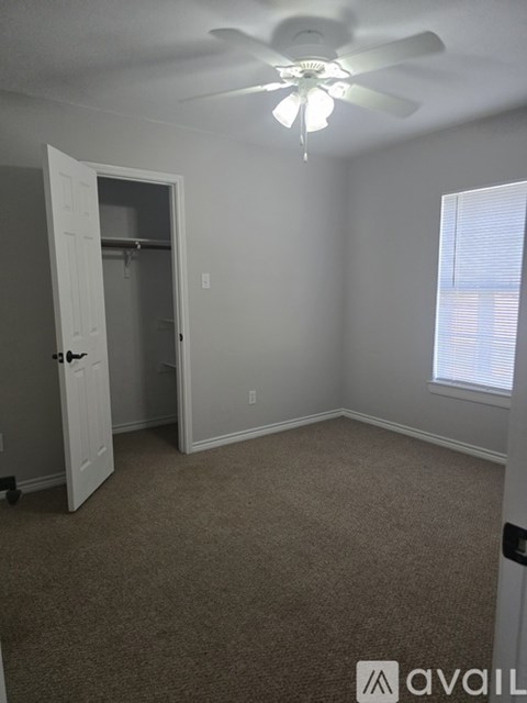 A room with a ceiling fan and carpeted floor.