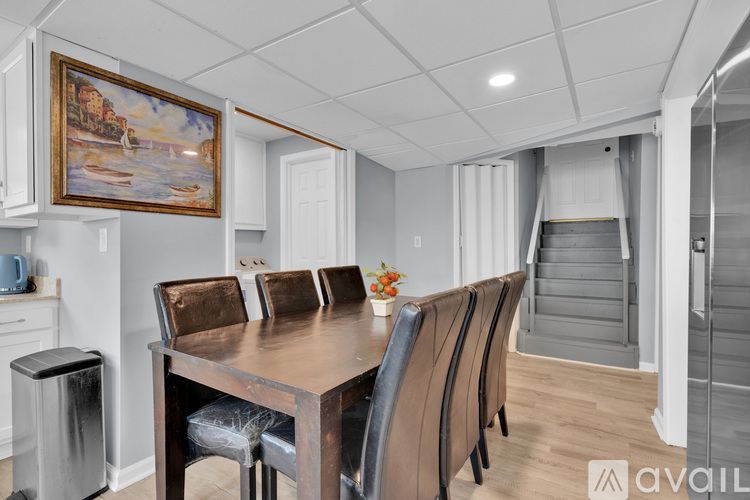 A dining room with a wooden table and chairs.