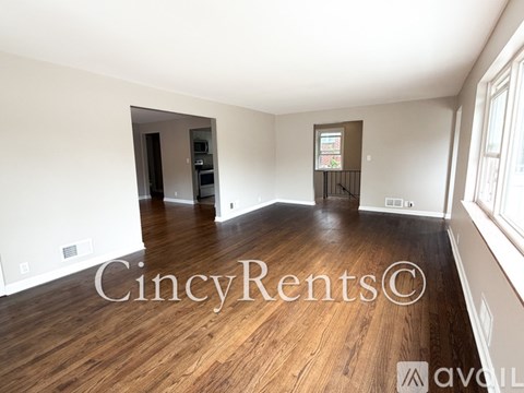 A spacious room with wooden floors and a large window.