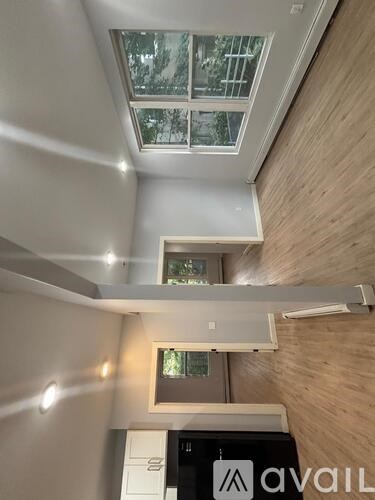 A room with a skylight and a wall-mounted air conditioner.
