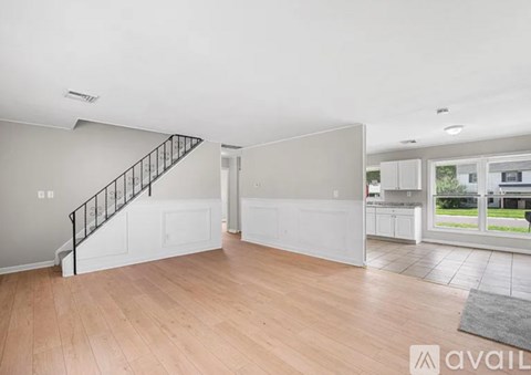 A spacious living room with a staircase leading to the upper floor.