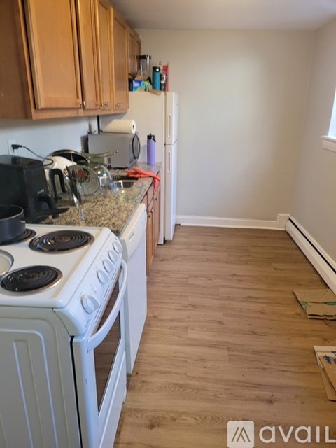 A kitchen with a white stove and wooden cabinets.