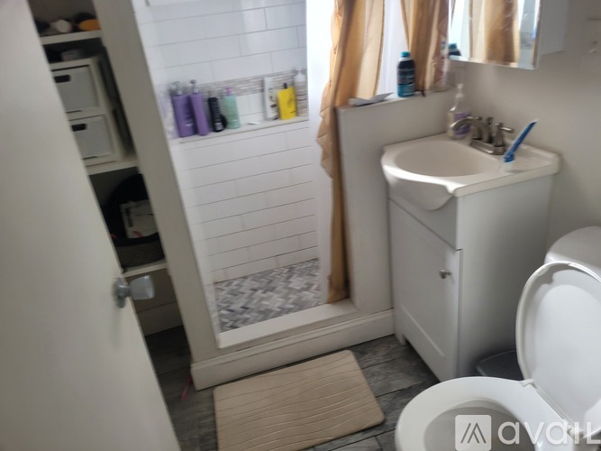 A bathroom with a white toilet, sink, and a shower with a glass door.