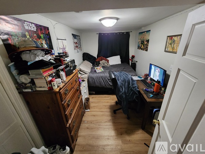 A messy bedroom with a Star Wars poster on the wall.
