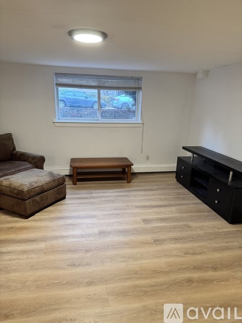 A living room with a brown couch, a wooden coffee table, and a black entertainment unit.