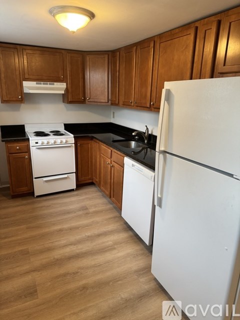 A kitchen with wooden cabinets and a white refrigerator.