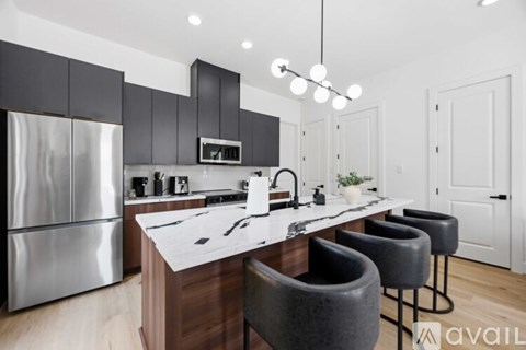 A modern kitchen with a center island and bar stools.