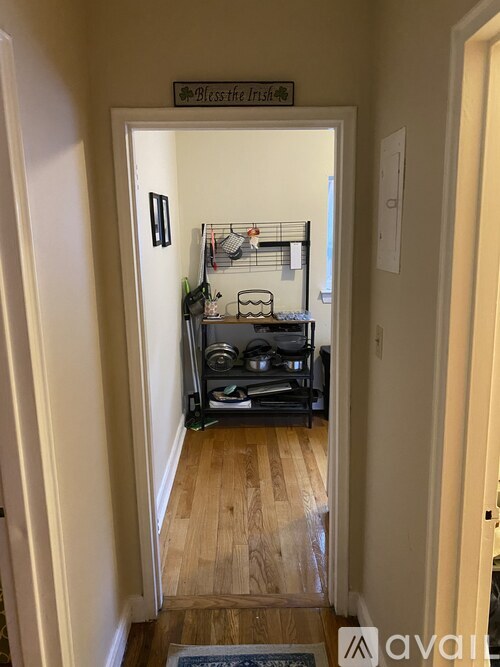 A hallway with a sign that says "bless the frisbee" above a door.